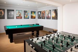 a room with a pool table and some posters at Motel Inn Simbach in Simbach am Inn