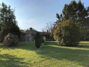 an old house in the middle of a field with trees at Une pause nature chez Marion et Cédric in Montignac-Toupinerie