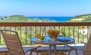 uma mesa com uma tigela de frutas e bebidas numa varanda em Margarita's Villas em Chania Town