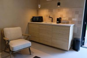 kuchnia z krzesłem i blatem z kuchenką mikrofalową w obiekcie Bed & Wijn - Suite 1 w mieście Staphorst