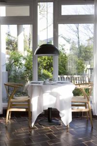 einen Tisch mit einer Lampe in einem Zimmer mit Fenstern in der Unterkunft Hotel Haus Norderney in Norderney