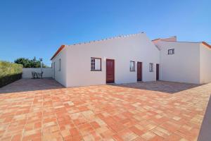 a large white house with a brick driveway at Villa Oliva Al iii in Moncarapacho