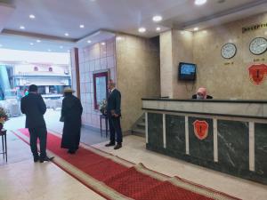 a group of men standing in a lobby at 26th of July Apartments in Alexandria