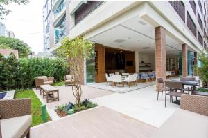a patio with chairs and tables in a building at Estanconfor Santos Vista Mar 4 AC Garagem sacada fechada in Santos