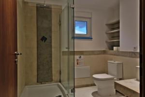 a bathroom with a toilet and a glass shower at Mega Ocean Magoito - Guest House - Sintra in Sintra