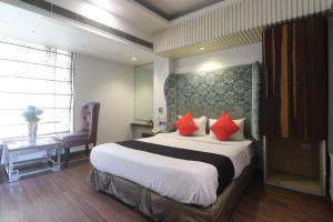 a bedroom with a large bed with red pillows at Hotel Uppal International - New Delhi Railway Station - Paharganj in New Delhi