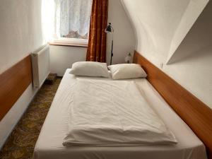 dwa łóżka w małym pokoju z oknem w obiekcie Hotel Górecki w Lidzbarku Warmińskim