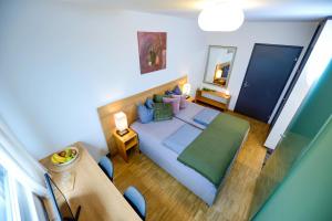 1 dormitorio con 1 cama grande y espejo en Hotel Profis, en Diepoldsau