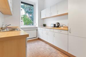 a kitchen with white cabinets and a window at Flatista Homes - Old Town in Munich +13 photos