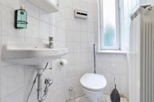 a white bathroom with a toilet and a sink at Flatista Homes - Old Town in Munich