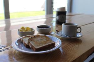 ein Tisch mit einem Teller Brot und Tassen Kaffee in der Unterkunft Dormís Acá in Esquel