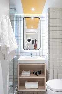 La salle de bains est pourvue d'un lavabo et d'un miroir. dans l'établissement Aparthotel Adagio Access Kiel, à Kiel