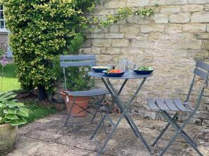 a table with two chairs and two bowls of food on it at Garden Barn in Farthinghoe