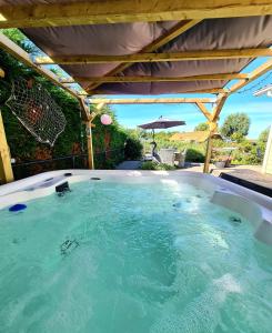 a large hot tub under a pergola at De Parel van Zeeland met jacuzzi en sauna in Sint Annaland