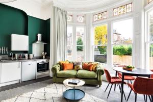 a living room with a green couch and a table at Your Apartment I Clifton House in Bristol