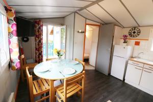 eine Küche und ein Esszimmer mit einem Tisch und Stühlen in der Unterkunft Camping La Tentation in Renty