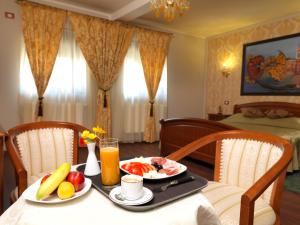una mesa con fruta y zumo en una habitación de hotel en La Favorita Guesthouse Boutique, en Craiova