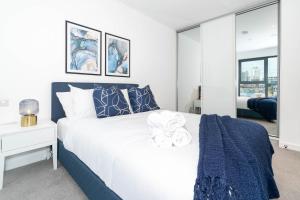 een slaapkamer met een groot wit bed met blauwe accenten bij Deluxe 1 Bedroom Stylish Apartment - City Centre in Birmingham