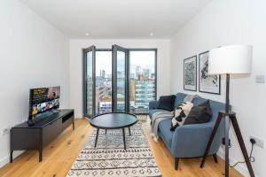 een woonkamer met een blauwe bank en een tv bij Deluxe 1 Bedroom Stylish Apartment - City Centre in Birmingham