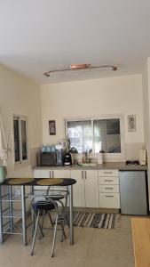 a kitchen with a table and two chairs in it at Rivkas zimmer in Ein Gedi