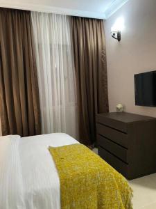 a bedroom with a bed and a dresser and a television at Metro Apartments in Lagos