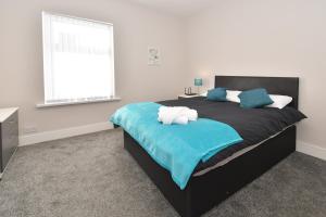 een slaapkamer met een groot bed en een raam bij Townhouse @ Warrington Road Stoke in Etruria