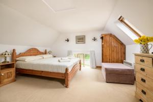 ein Schlafzimmer mit einem Bett und einer Kommode in der Unterkunft Luccombe Farm Holiday Cottages in Milton Abbas + 145 Fotos