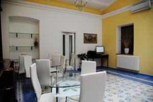 una sala da pranzo con sedie bianche e un tavolo di Arte & Mare a Patti