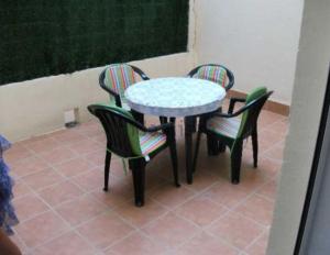 a table with four chairs and a table with a table and chairs at Precioso apartamento 1ª linea playa con piscina in Vinaròs