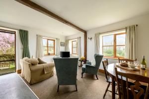 ein Wohnzimmer mit Sofa und Tisch in der Unterkunft Luccombe Farm Holiday Cottages in Milton Abbas