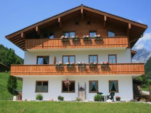 a large house with flower boxes on the balcony at Bartmann Ferienwohnungen in Ramsau