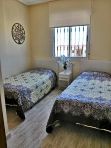 1 Schlafzimmer mit 2 Betten und einem Fenster in der Unterkunft Nice apartment in quiet area Aguas Nuevas in Torrevieja