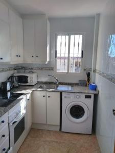 eine Küche mit einer Waschmaschine und einem Waschbecken in der Unterkunft Nice apartment in quiet area Aguas Nuevas in Torrevieja