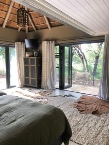 1 dormitorio con cama y vistas a un ciervo exterior en Simba Safaris African Pride Exotic Lodge en Lephalale