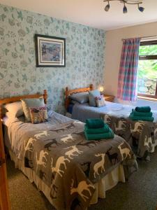 1 dormitorio con 2 camas en una habitación en Snowberry Cottages No1, en Onich