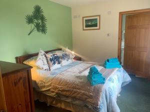 una camera da letto con un letto con asciugamani blu di Snowberry Cottages No1 a Onich