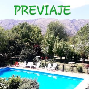 a swimming pool with chairs and mountains in the background at La Candida Hotel in Merlo