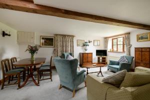 ein Wohnzimmer mit Tisch und Stühlen in der Unterkunft Luccombe Farm Holiday Cottages in Milton Abbas