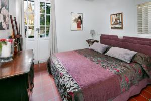 a bedroom with a bed and a table and window at Domaine de Néron in Le Moule
