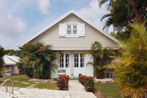 a white house with a window and some palm trees at Domaine de Néron in Le Moule