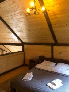 een slaapkamer met een bed in een houten hut bij Шале "Конопка" in Boekovel