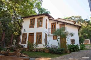 a large white house with a large window at Villa Rica Pousada Boutique in Brumadinho