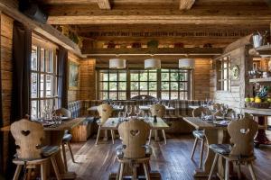 a restaurant with wooden walls and tables and chairs at Le Refuge de la Traye in Méribel