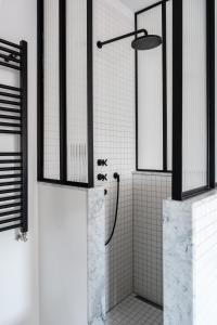 a bathroom with a shower with white tile walls at Morgan & Mees Amsterdam in Amsterdam