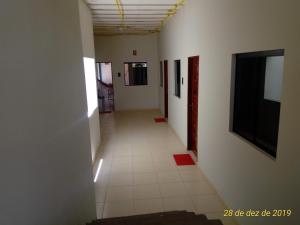 a hallway with white walls and a white tile floor at Flat Japaratinga Beach in Japaratinga