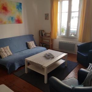 a living room with a blue couch and a coffee table at Granville Plage Plat Gousset in Granville
