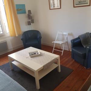 a living room with a coffee table and two chairs at Granville Plage Plat Gousset in Granville