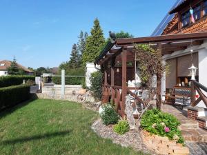 un cortile con pergolato in legno e panca di Ferienwohnung Maroldsweisach a Maroldsweisach