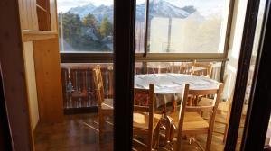 Una mesa y sillas en una habitación con ventana. en LA JOUE DU LOUP STUDIO, en La Joue du Loup