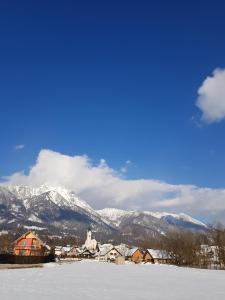 a snow covered town with mountains in the background at Pr'Simi in Golnik